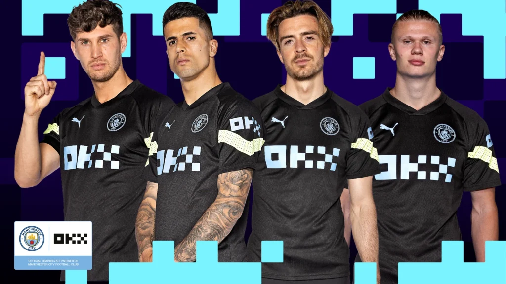 Manchester City players Erling Haaland, Jack Grealish, and teammates in the official training kit featuring OKX, the club's official crypto exchange partner for 2026